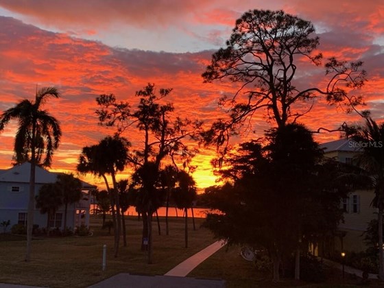 You can enjoy many evening sunsets like these! Home is the yellow home on right. - Single Family Home for sale at 6751 Portside Ln, Englewood, FL 34223 - MLS Number is N6118322